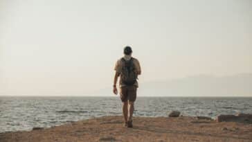 Backpacker kijkt uit over een bestemming bereikt op een klein reisbudget