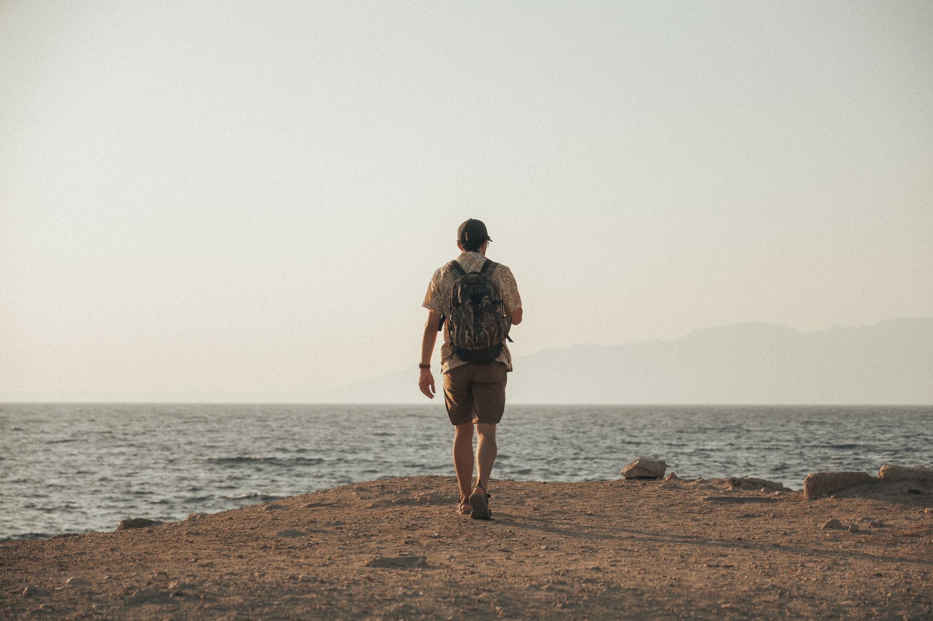 Backpacker kijkt uit over een bestemming bereikt op een klein reisbudget
