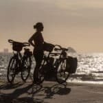 Reiziger op de fiets langs een kustweg tijdens zonsopgang