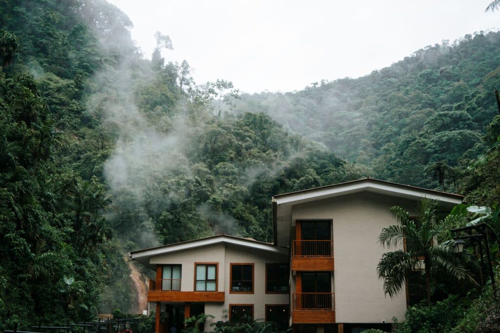 Houten eco-lodge op palen boven groen regenwoud