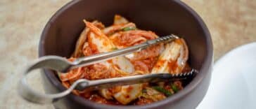 Kommen met gefermenteerd eten zoals yoghurt, zuurkool en kimchi op een houten tafel