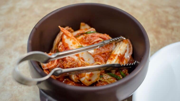 Kommen met gefermenteerd eten zoals yoghurt, zuurkool en kimchi op een houten tafel