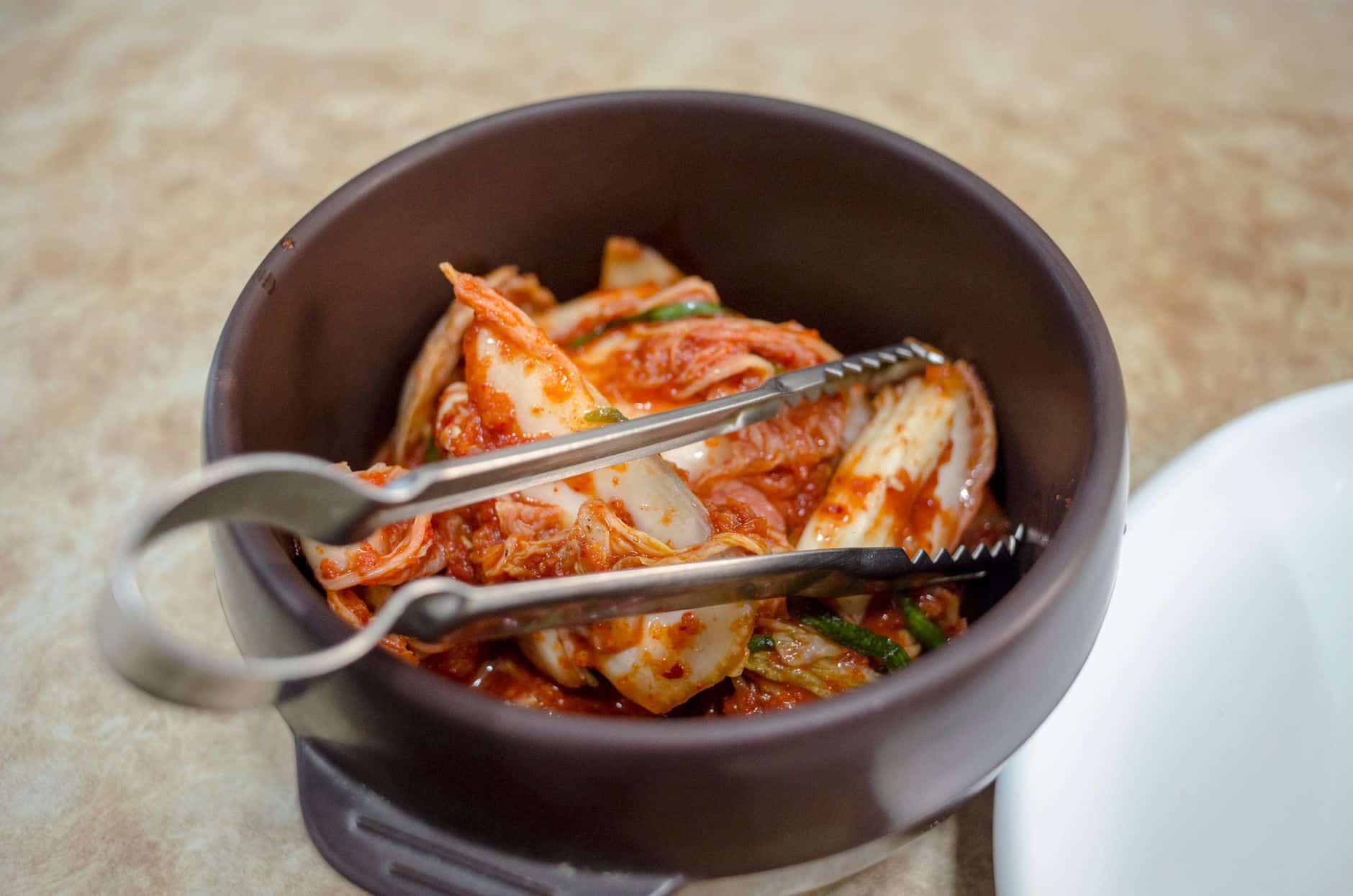Kommen met gefermenteerd eten zoals yoghurt, zuurkool en kimchi op een houten tafel