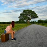 Vrouw met rugzak kijkt uit over een landschap tijdens een solo reis
