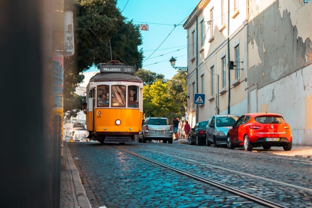 Kleurrijke straat in Lissabon met een gele tram, ideale bestemming voor solo reizen