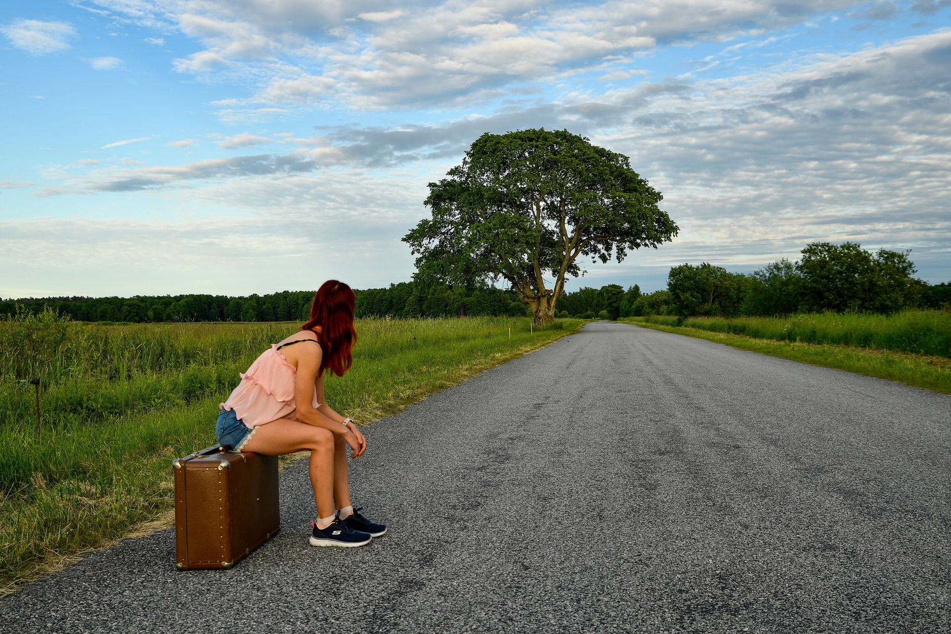 Vrouw met rugzak kijkt uit over een landschap tijdens een solo reis